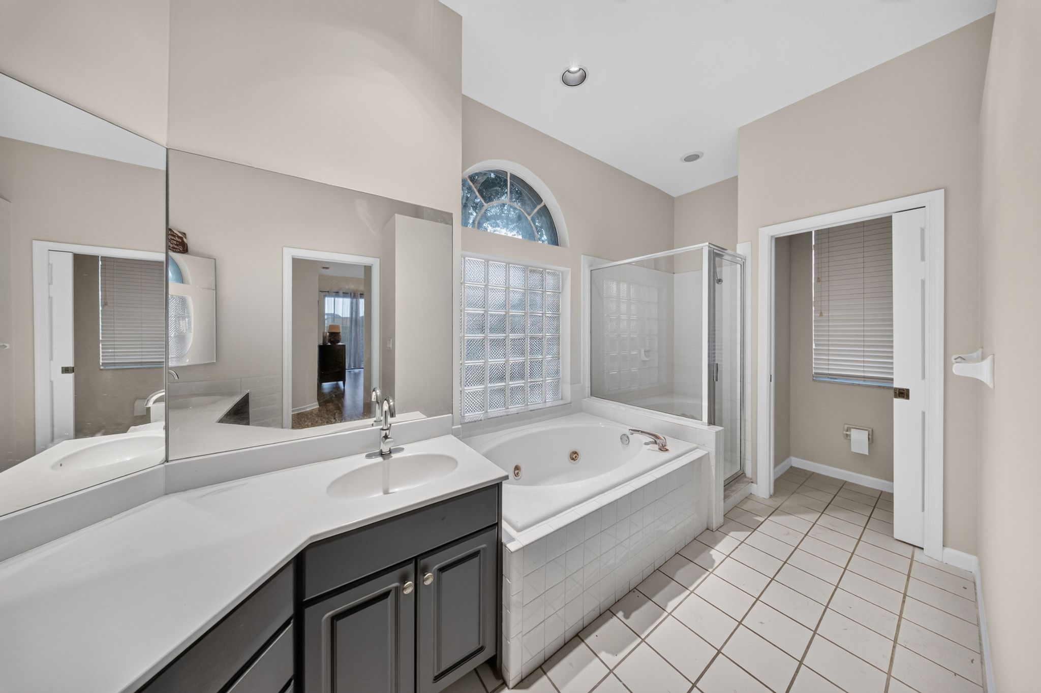 Primary bathroom with soaking tub and arched window
